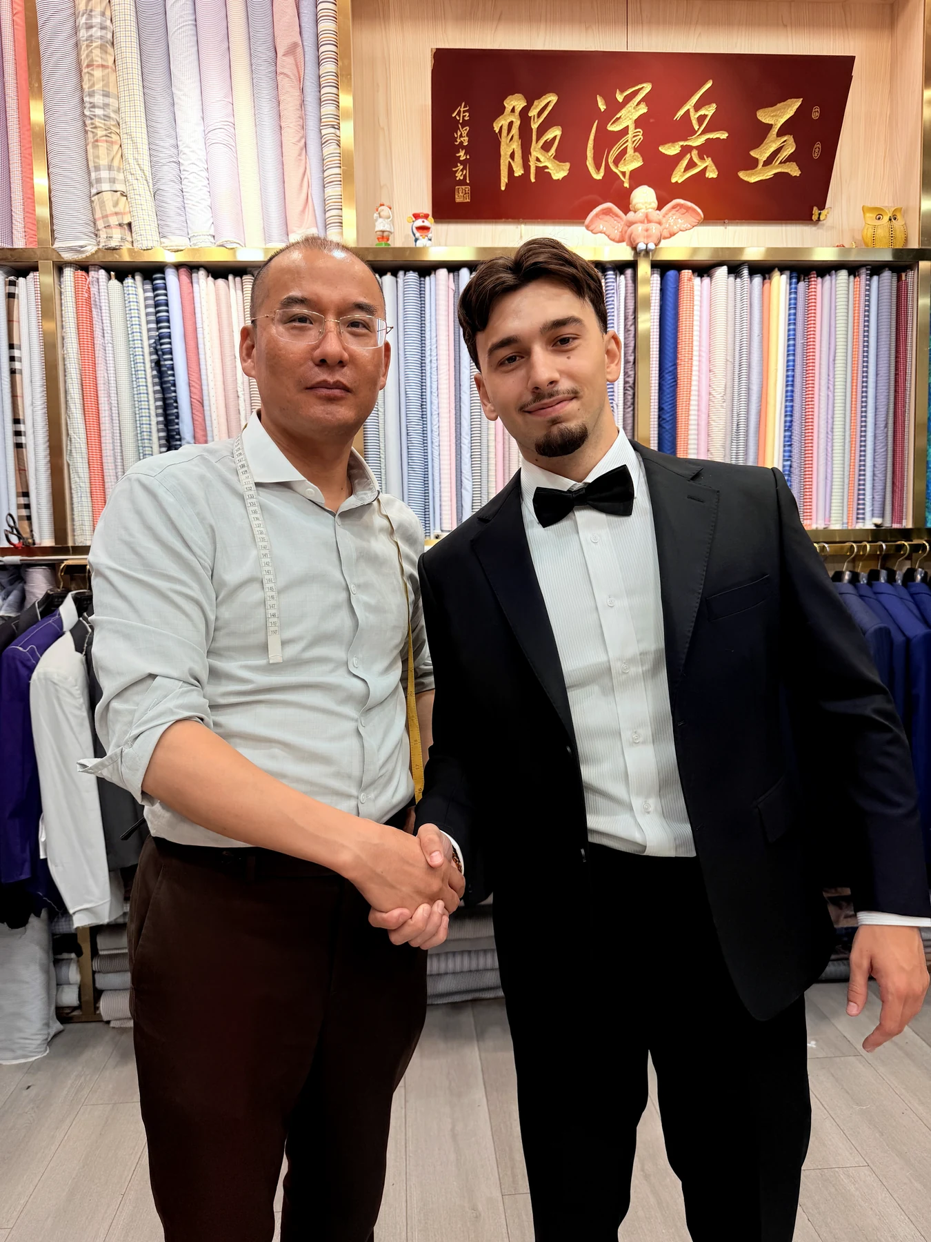 黑色礼服客户与五岳洋服裁缝握手合影